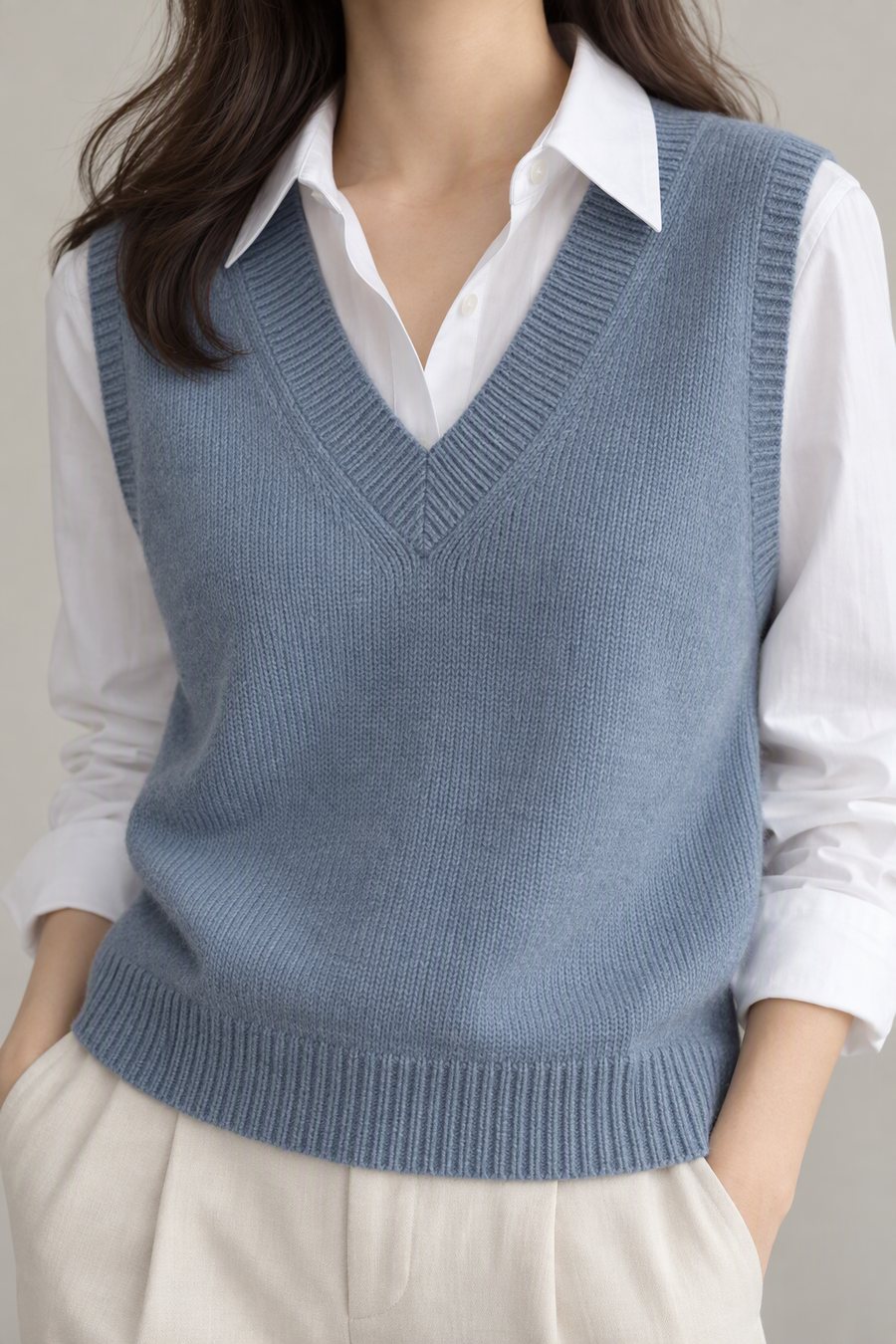 Dusty blue V-neck knitted vest over a white shirt